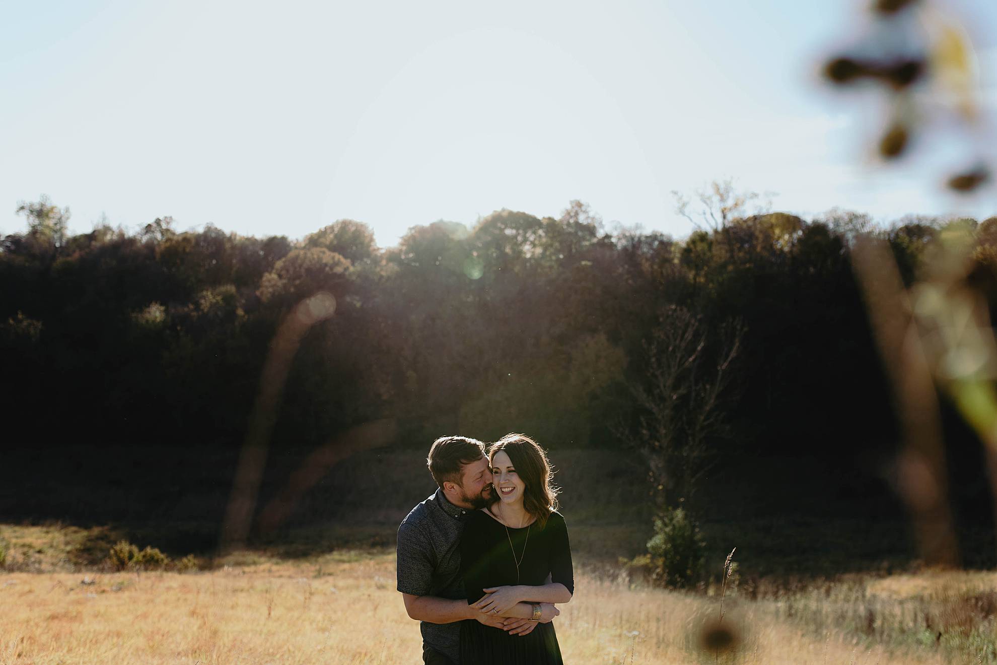 couple embracing and laughing at engagement session in neale woods