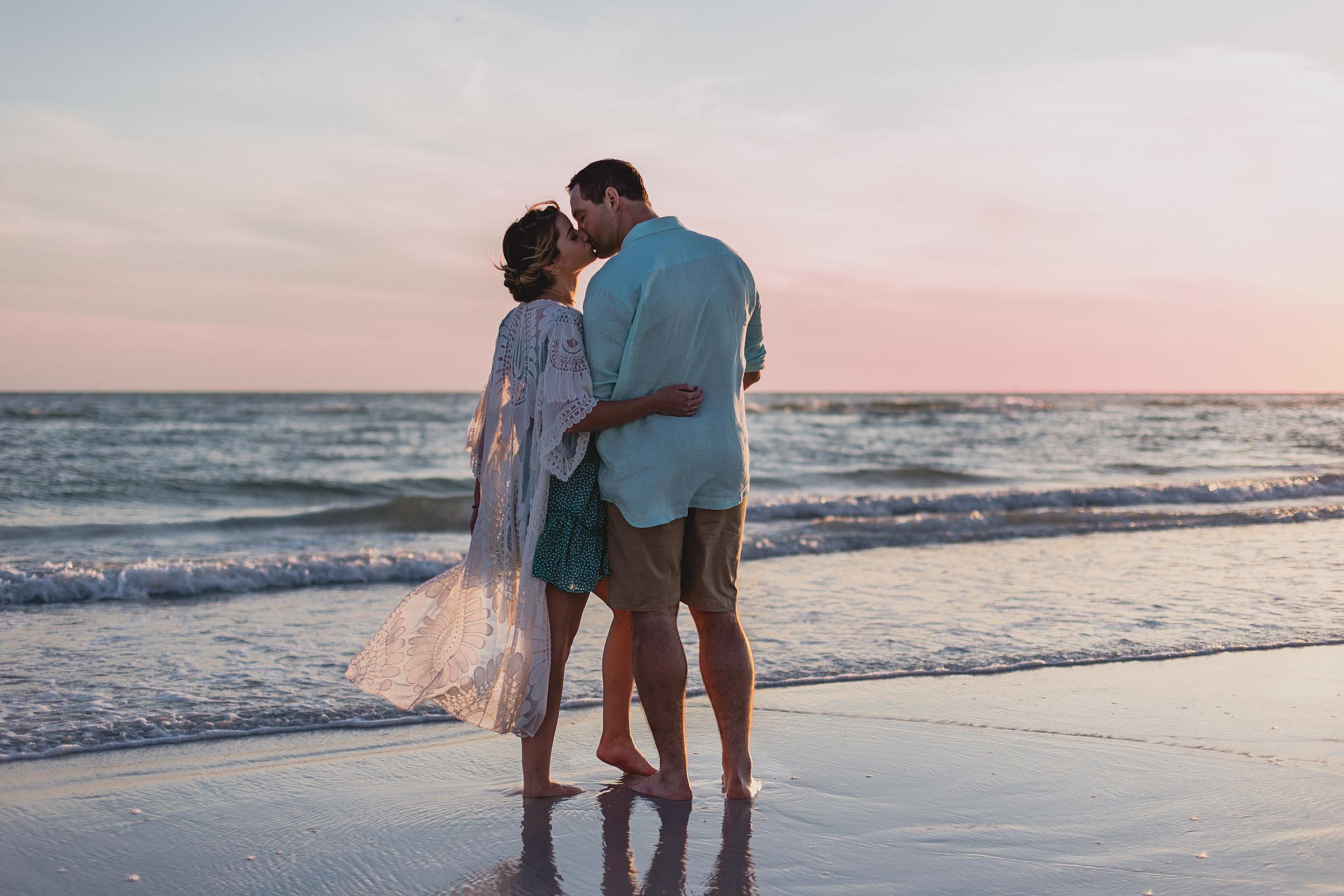 couple kissing at engagement session on siesta key beach