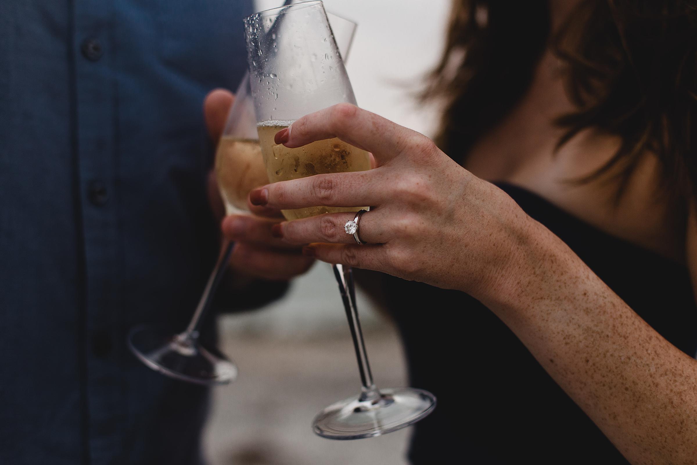 Engagement session on caspersen beach in venice, florida, close up of engagement ring with champagne glasses