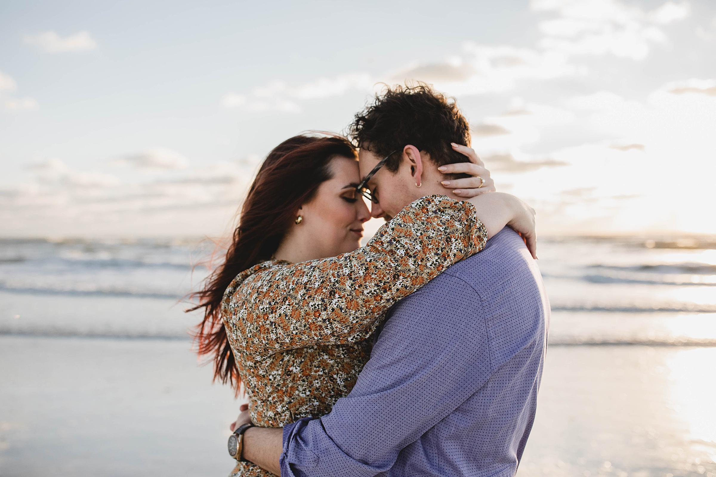 couple embracing with foreheads together on Lido Beach in Florida during Sarasota engagement session, juliana montane photography, sarasota proposal photographer