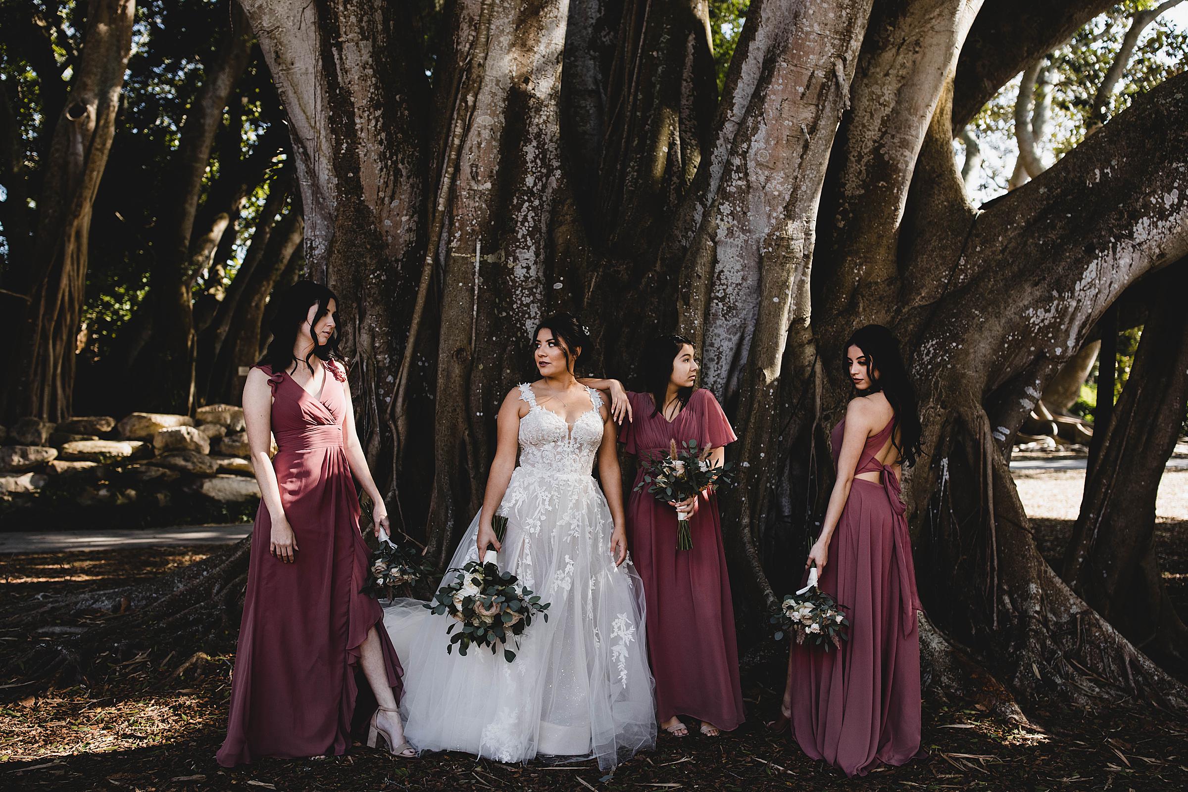 bridemaids posing in front of a banyan tree at Marie Selby Botanical Gardens in sarasota Florida