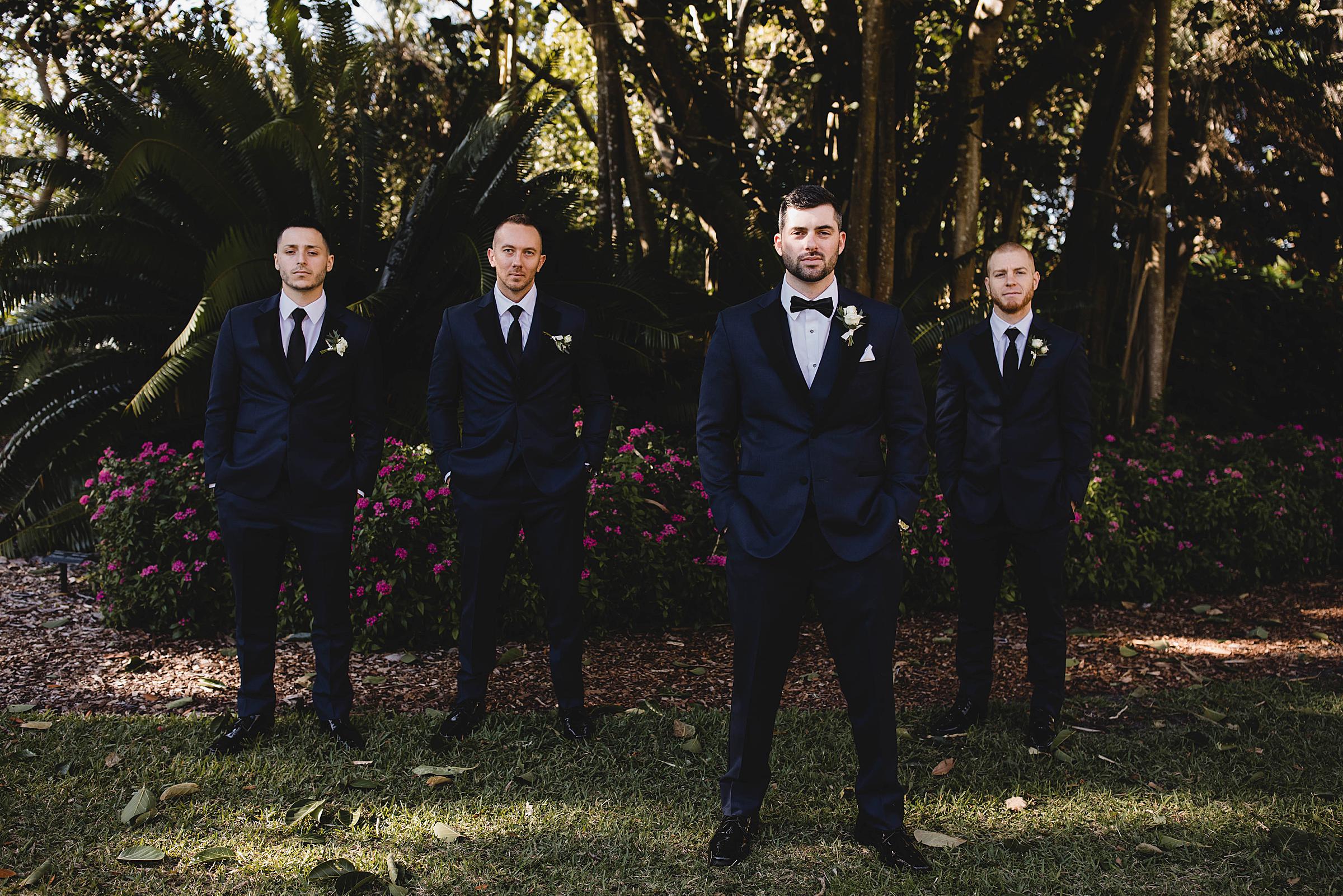 groomsmen posing in from of greenery at Marie Selby Botanical Gardens in sarasota florida, photographed by Juliana Montane