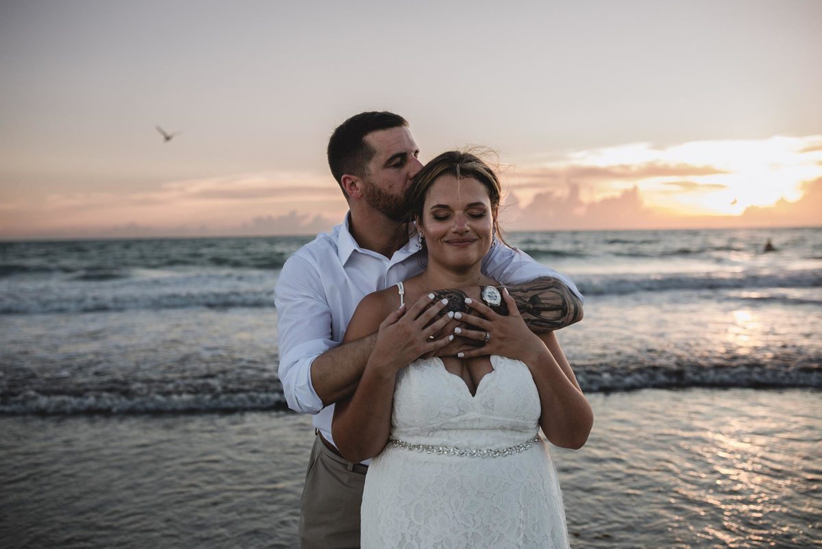 bride and groom embracing at clearwater beach elopement photographed by juliana montane photography