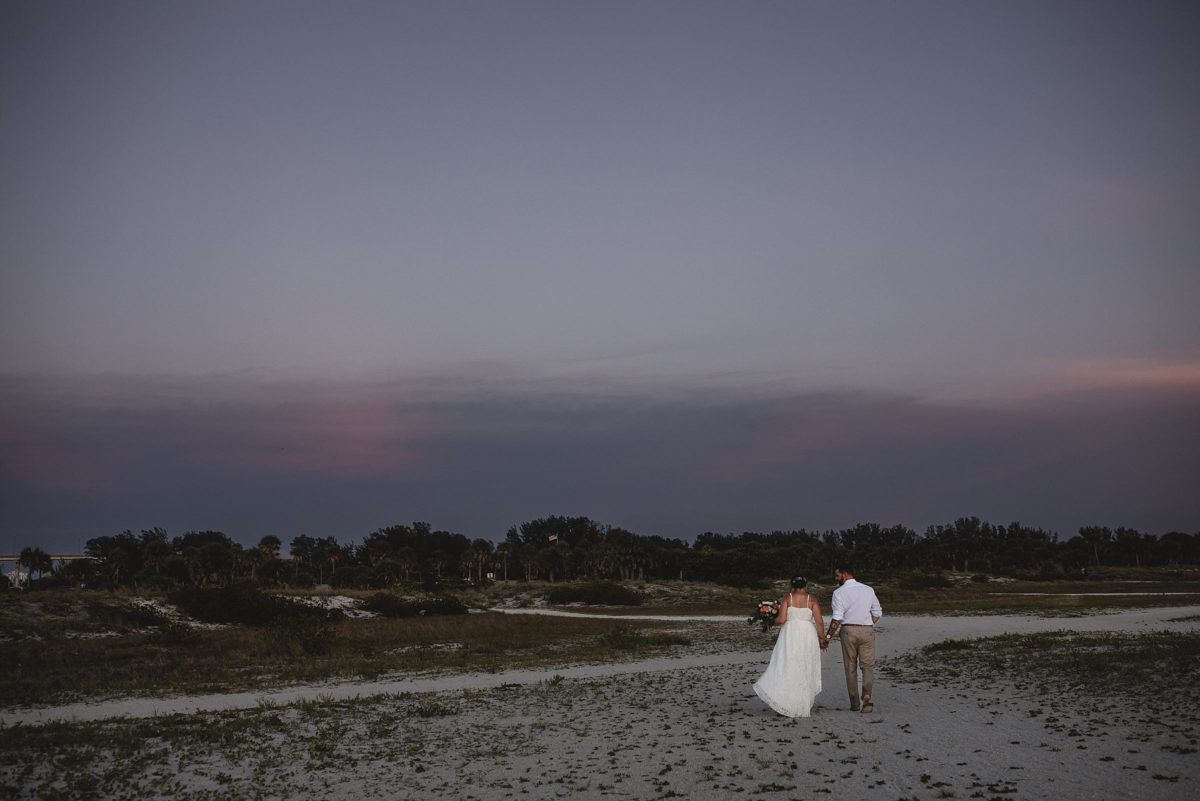 bride and groom walking at sunset at clearwater beach elopement photographed by juliana montane photography