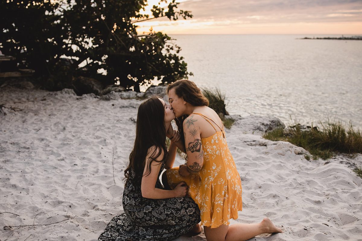 Women kissing after surprise proposal on st pete beach in florida, photographed by juliana montane