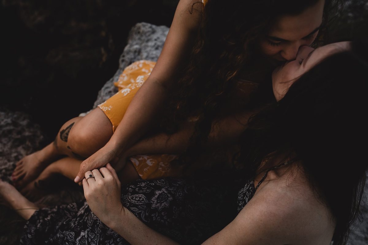 Women kissing and holding hands photographed by Juliana Montane Photography
