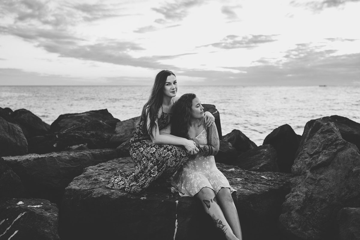Couple embracing on top of a rock on st pete beach florida, photographed by Juliana Montane Photography