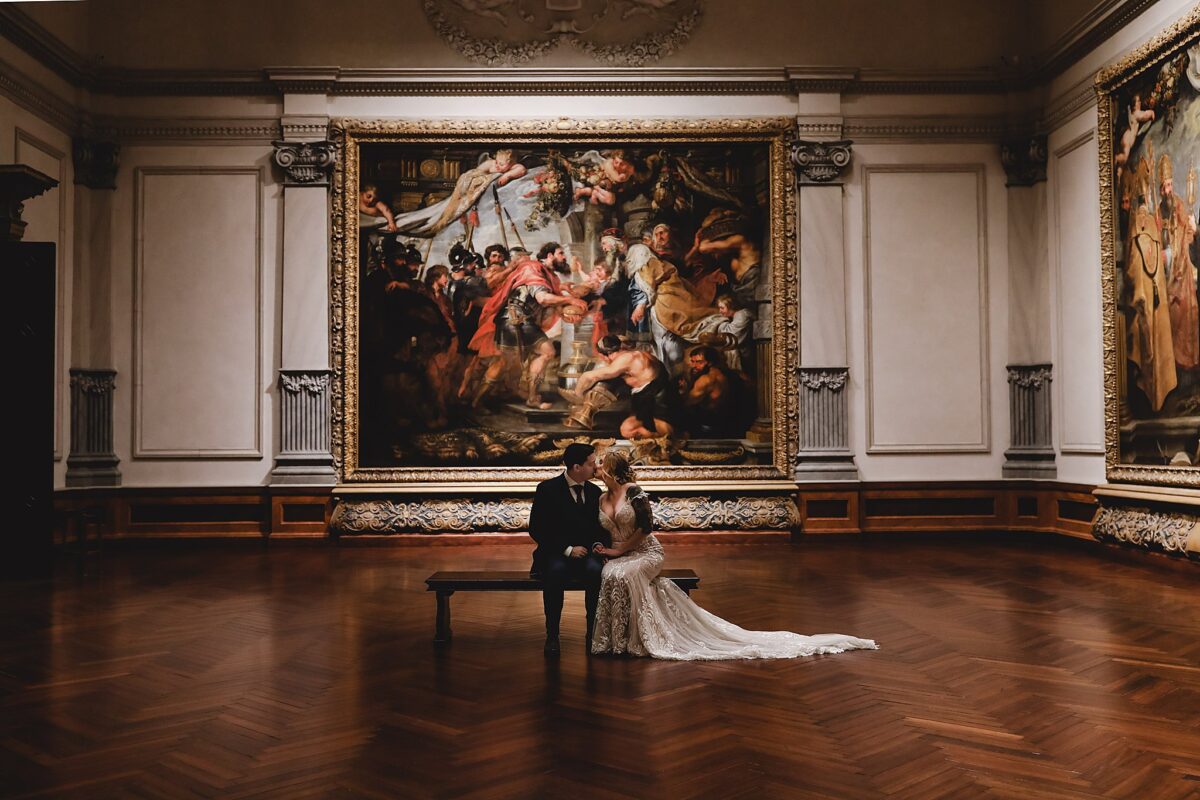 couple sitting on bench together inside art museum at john ringling museum on wedding day in sarasota fl, wedding photography by juliana montane photography