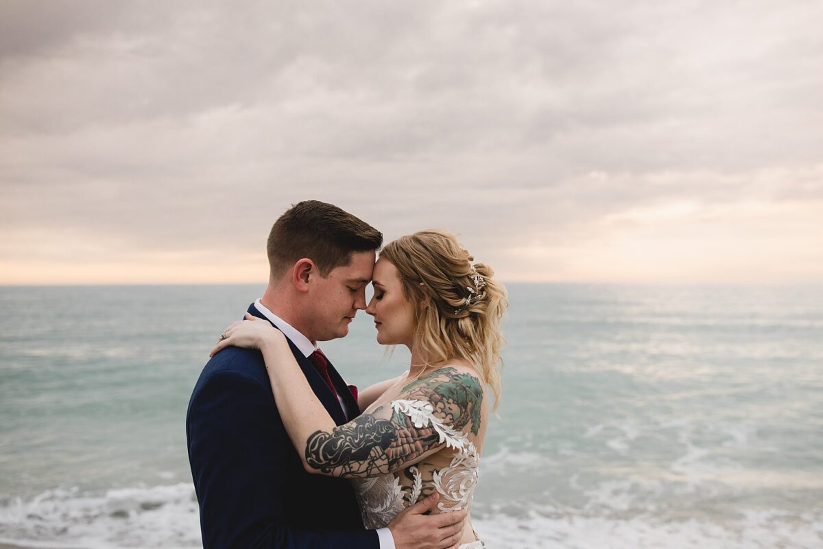 Bride and groom leaning their heads together during sunset on turtle beach in sarasota florida and siesta key, wedding photography by juliana montane photography