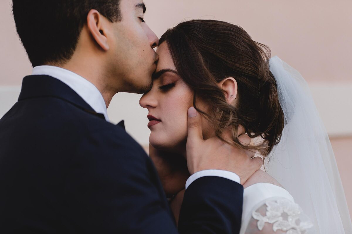 Groom kissing bride on the forehead after wedding ceremony at the Sarasota Courthouse photographed by Juliana Montane Photography