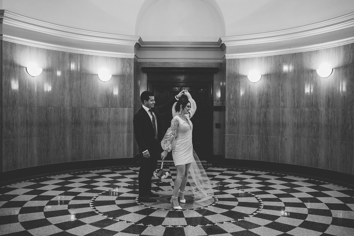 Groom and Bride pretending to dance inside sarasota courthouse after wedding ceremony photographed by Juliana Montane Photography