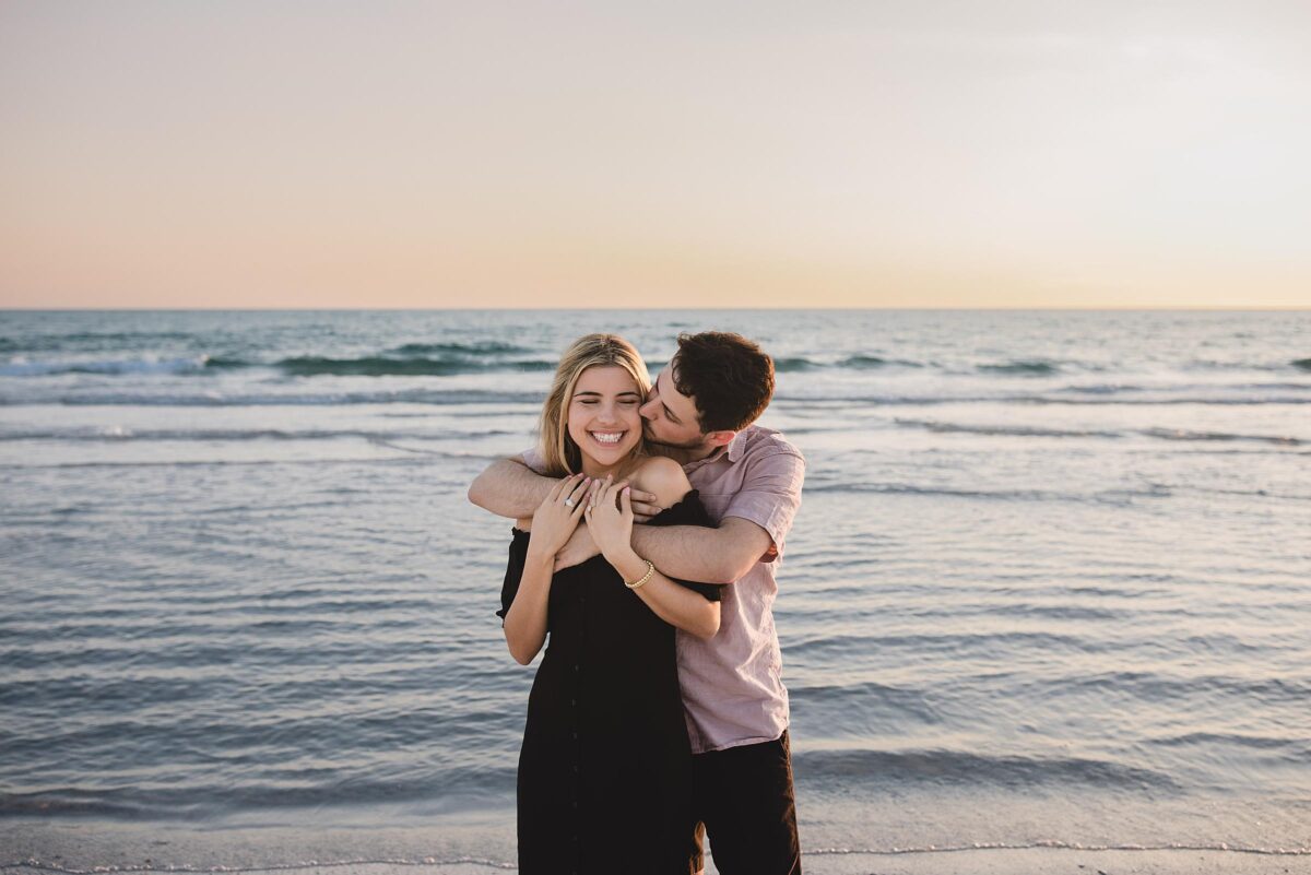 Couple embracing and smiling after getting engaged on siesta key beach in sarasota florida photographed by Juliana Montane Photography