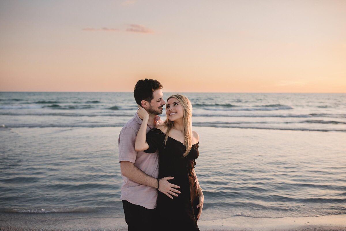 Couple looking into each other's eyes with water in the background after getting engaged on siesta key beach in sarasota florida photographed by Juliana Montane Photography