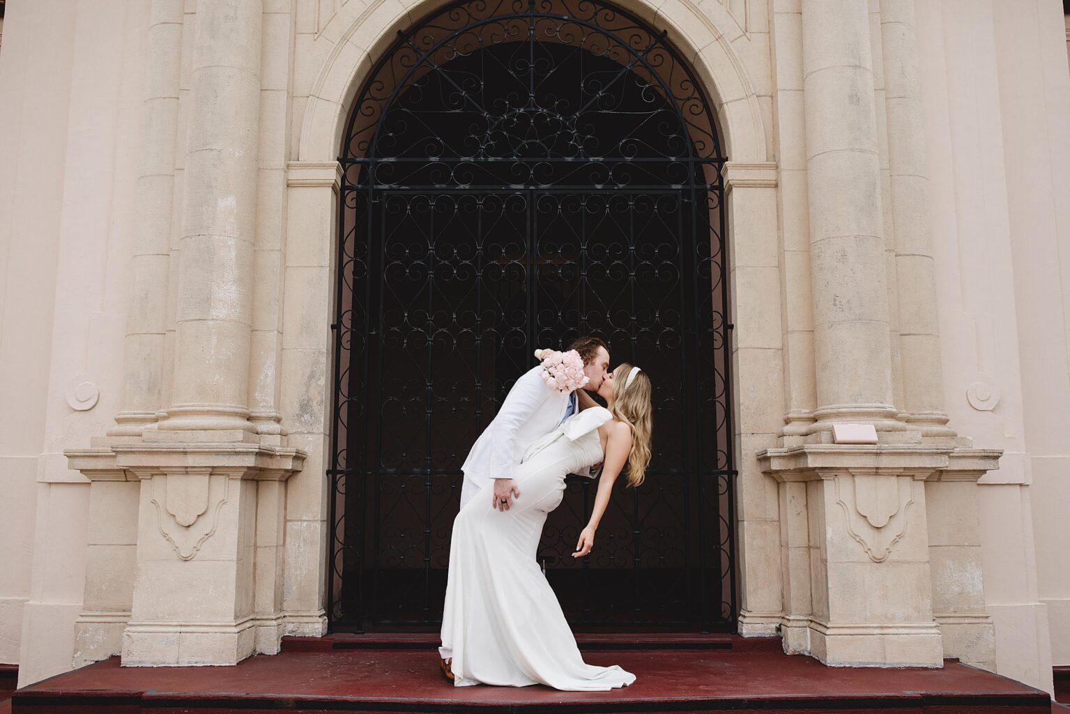 couple kissing in front of the sarasota courthouse after eloping