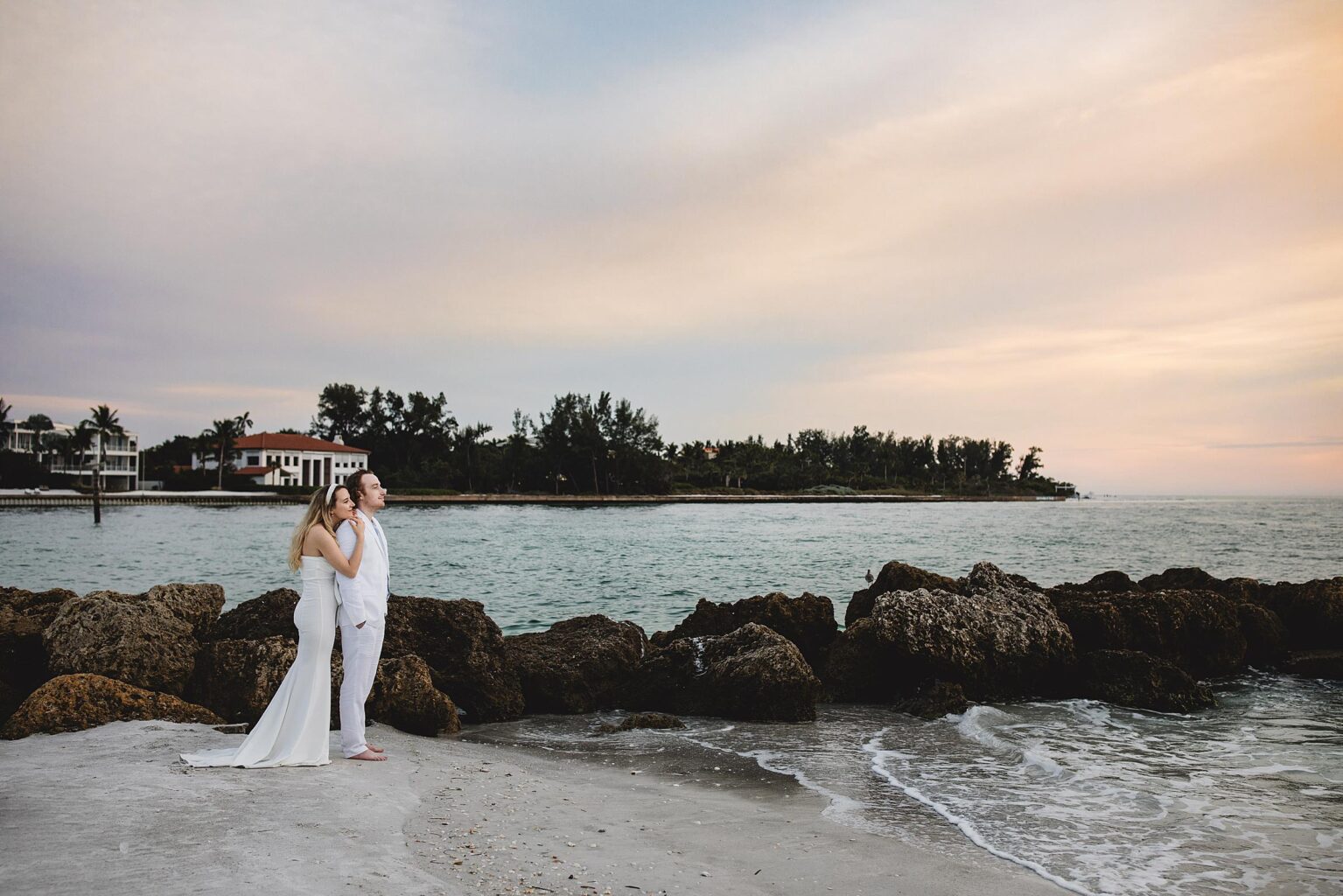 couple embracing on longboat key beach after their elopement at the sarasota courthouse