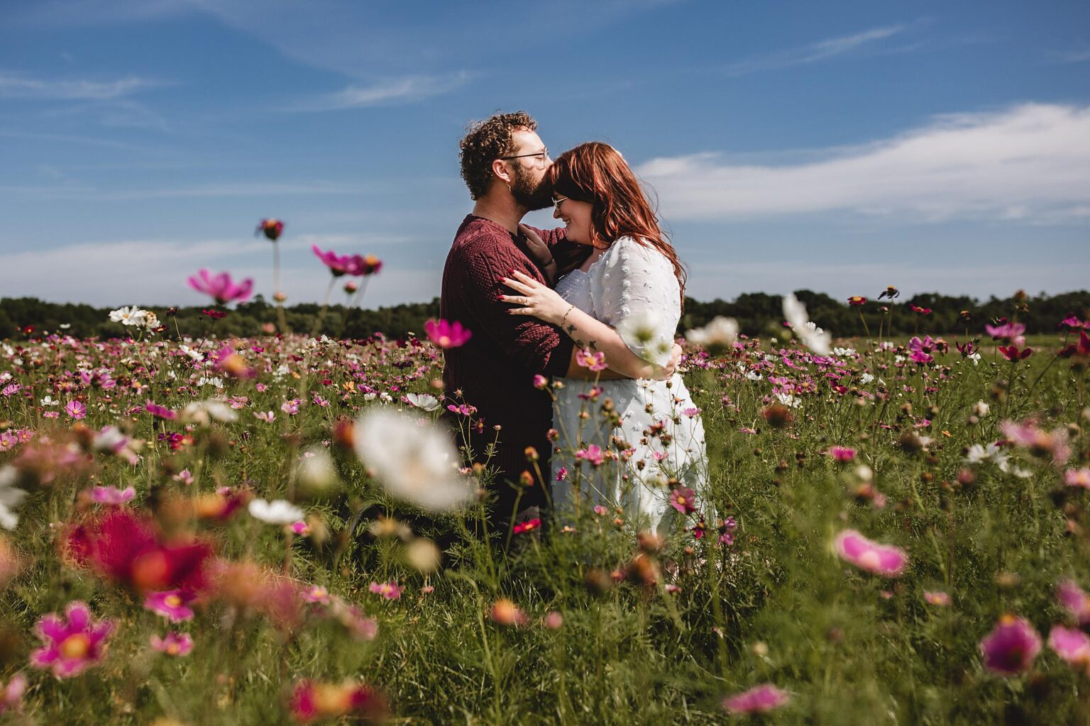 Newly Engaged couple surrounded by wildflowers at Hunsader Farm after surprise proposal in Sarasota. Photographed by Juliana Montane Photography.