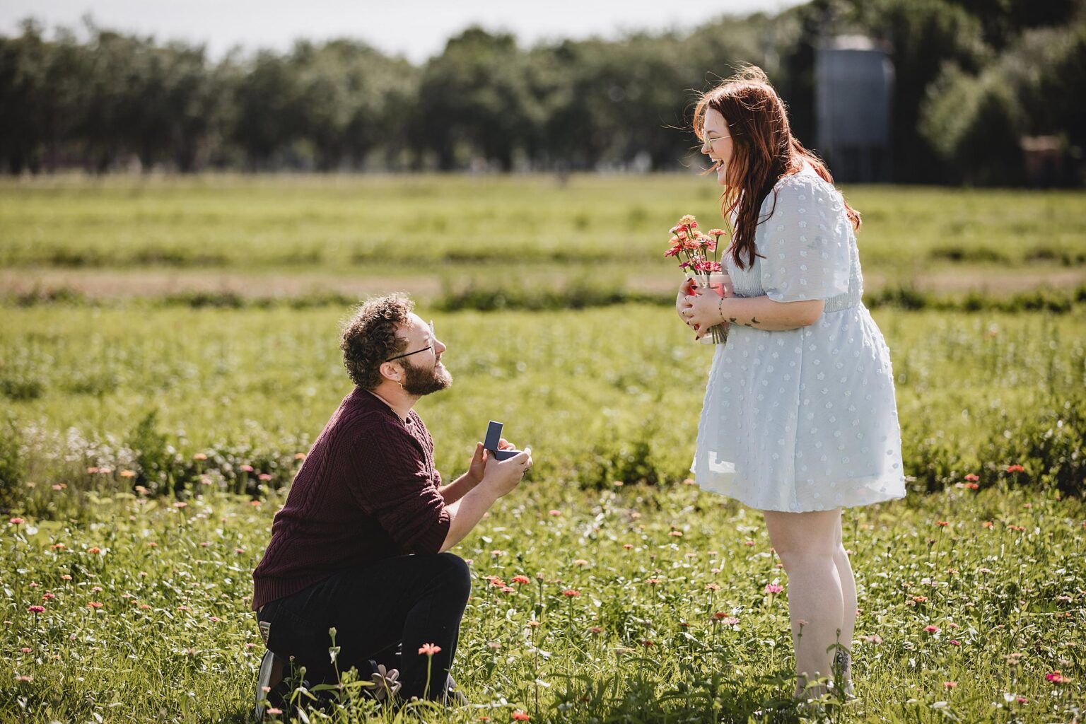 Couple getting engaged in the flower field at Hunsader Farm in Sarasota, Florida. Photographed by Juliana Montane Photography.