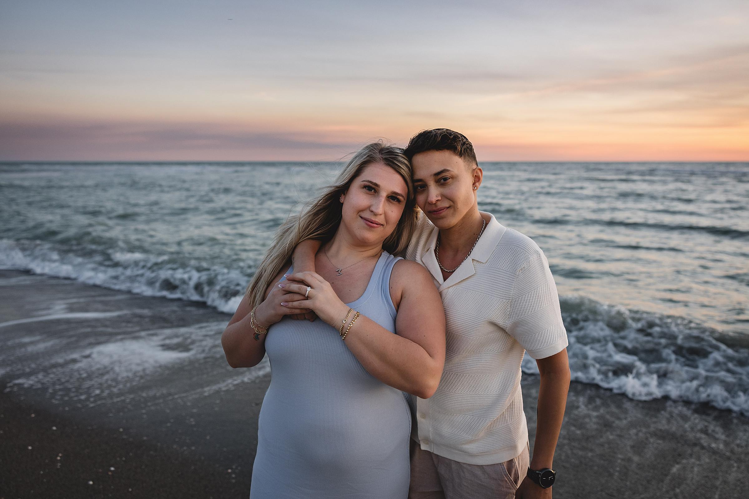 Same sex couple embracing on the beach during engagement session on the beach in Florida. Photographed by Juliana Montane Photography