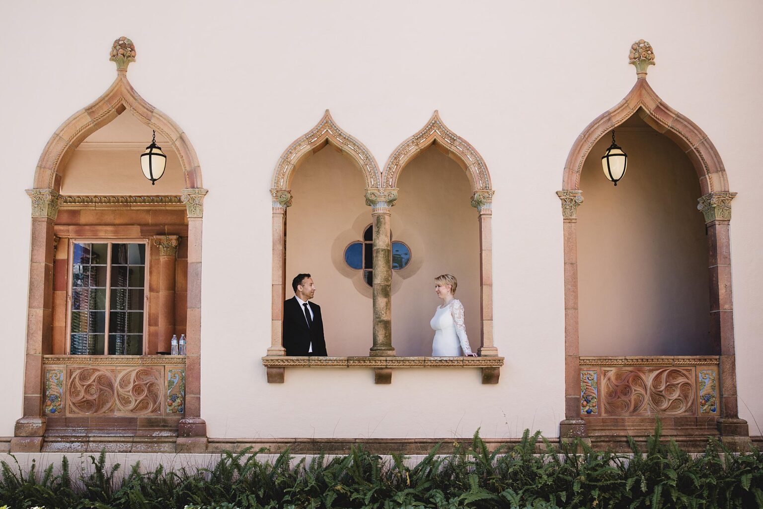 Bride & Groom posing in the archways of the Ca d'Zan Building at Ringling Museum in Sarasota, FL. Photographed by Juliana Montane Photography.