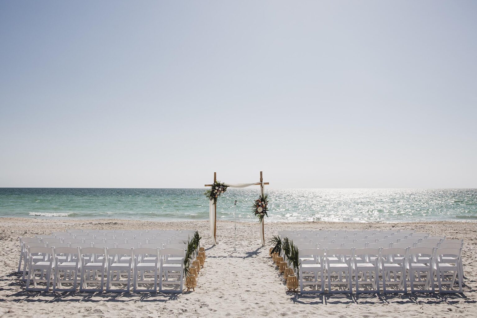 Ceremony setup with arch on the beach. Photographed by Juliana Montane Photography.