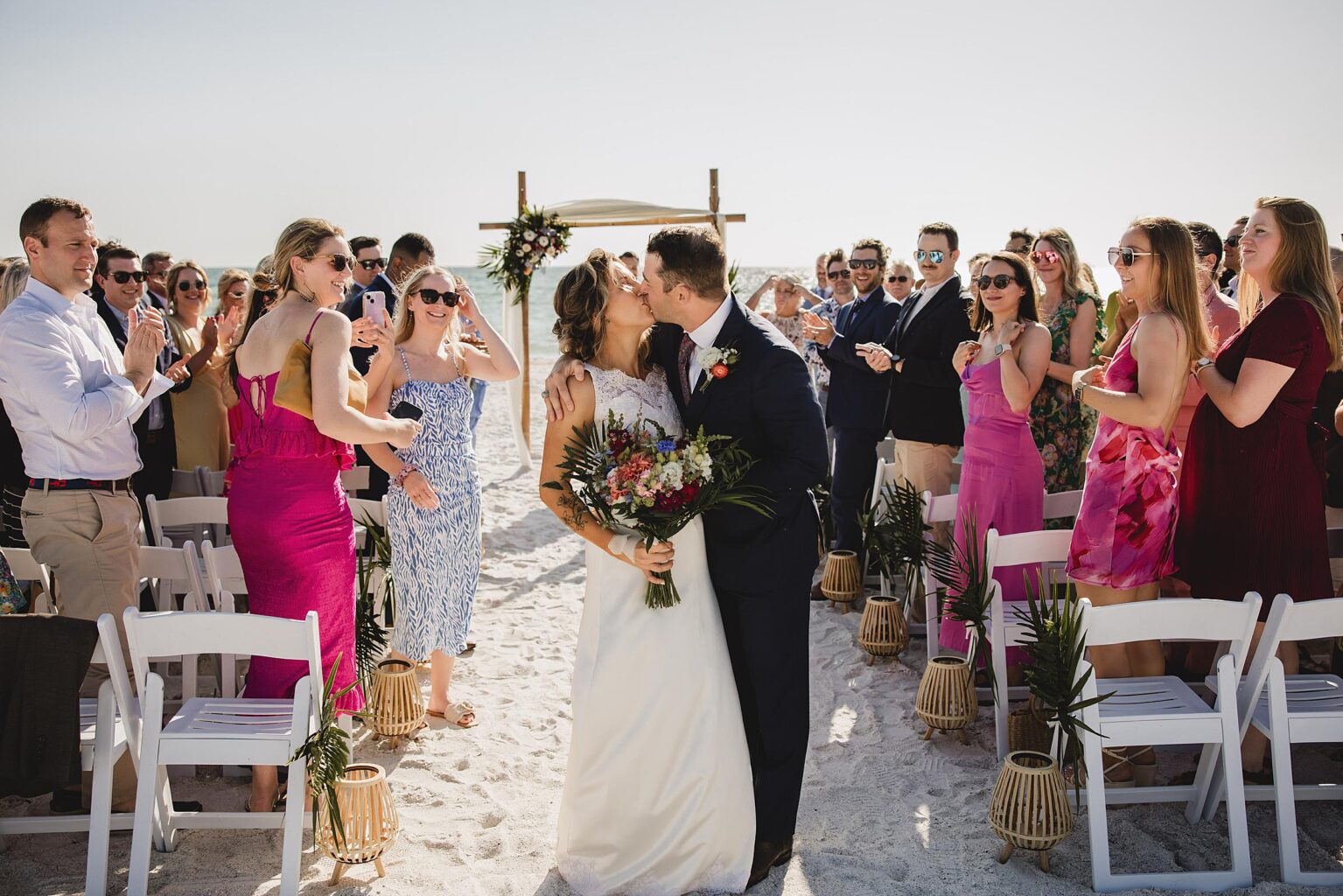 Bride & Groom kissing at the end of their ceremony at the Beach House on Bradenton Beach, FL. Photographed by Juliana Montane Photography.