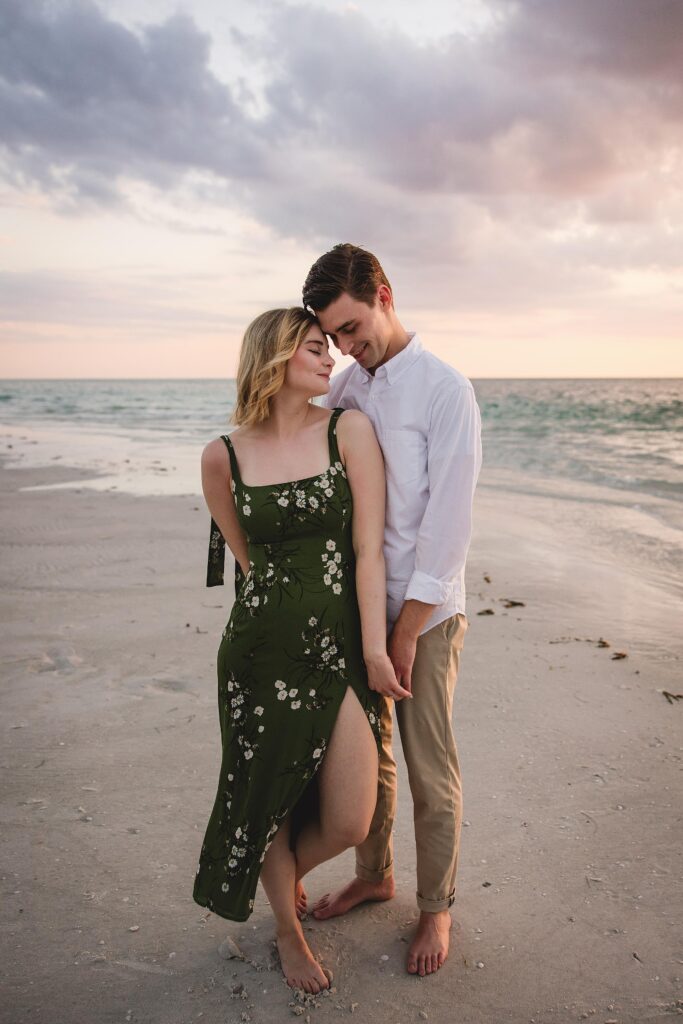 Couple smiling with their heads together at a Siesta Key engagement session. Photographed by Juliana Montane Photography.