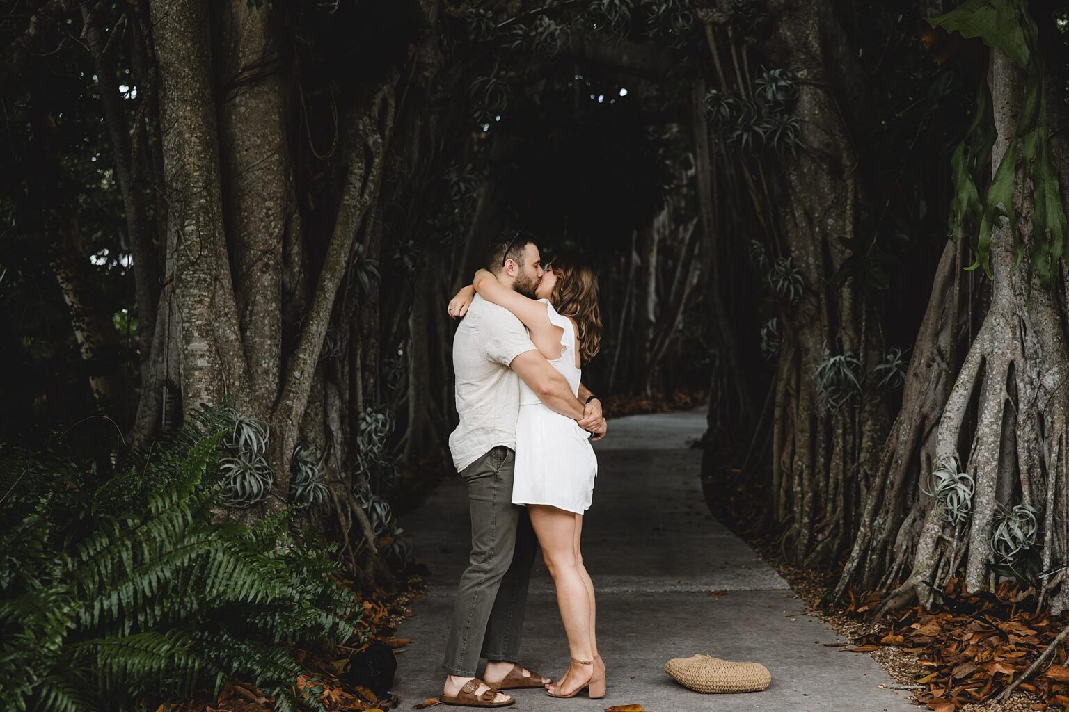 Couple kissing after surprise proposal at Selby Gardens in Sarasota, Florida. Photographed by Juliana Montane Photography.