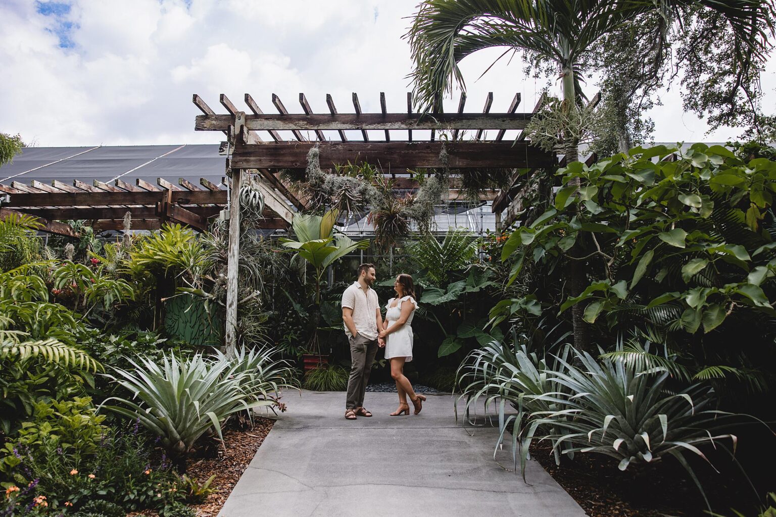 Couple posing and looking at eachother during engagement session at selby gardens surprise proposal. Photographed by Juliana Montane Photography.