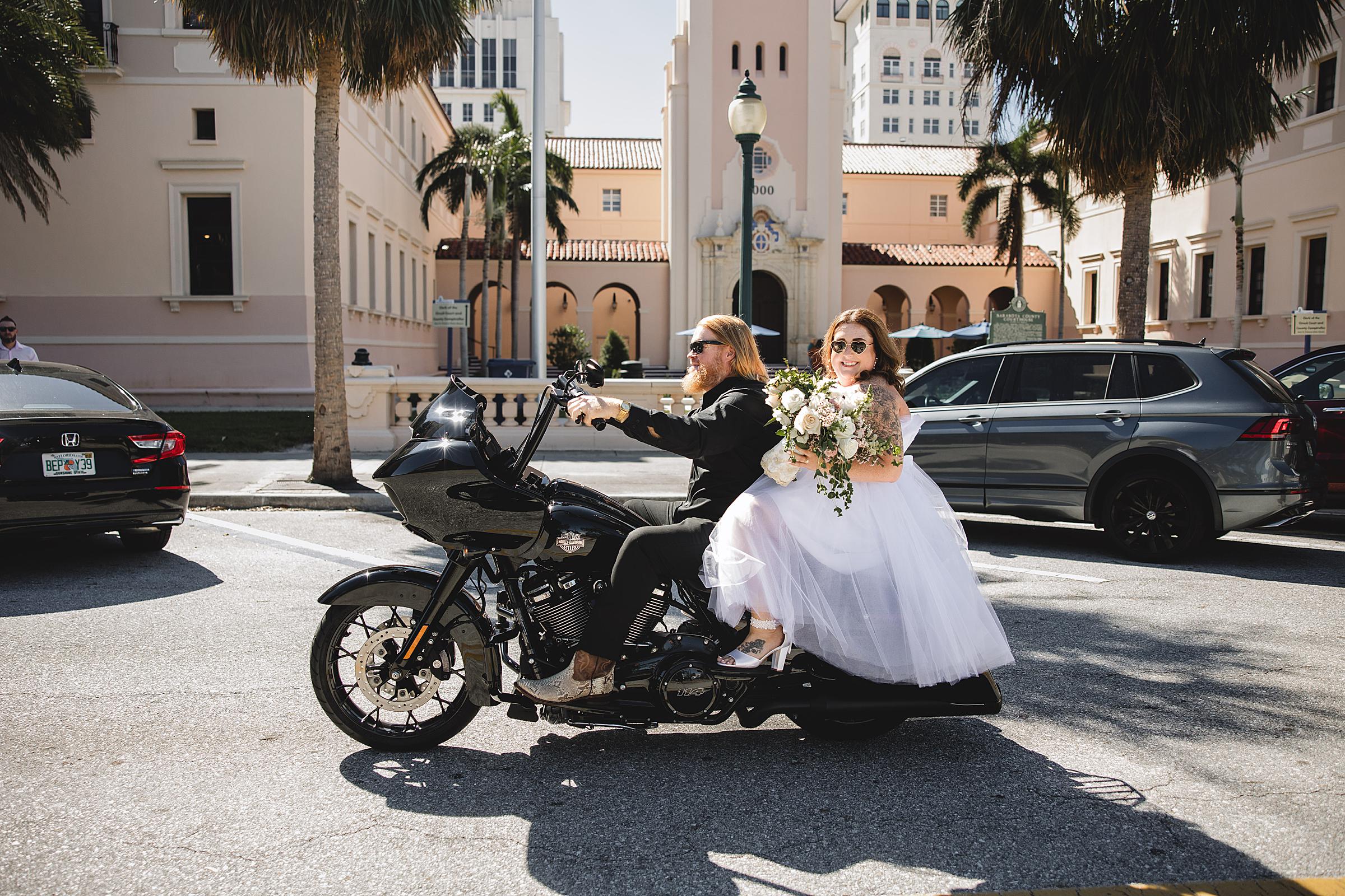 Bride & Groom riding off from ceremony on motorcycle at Sarasota Elopement at Sarasota Courthouse photographed by Juliana Montane Photography