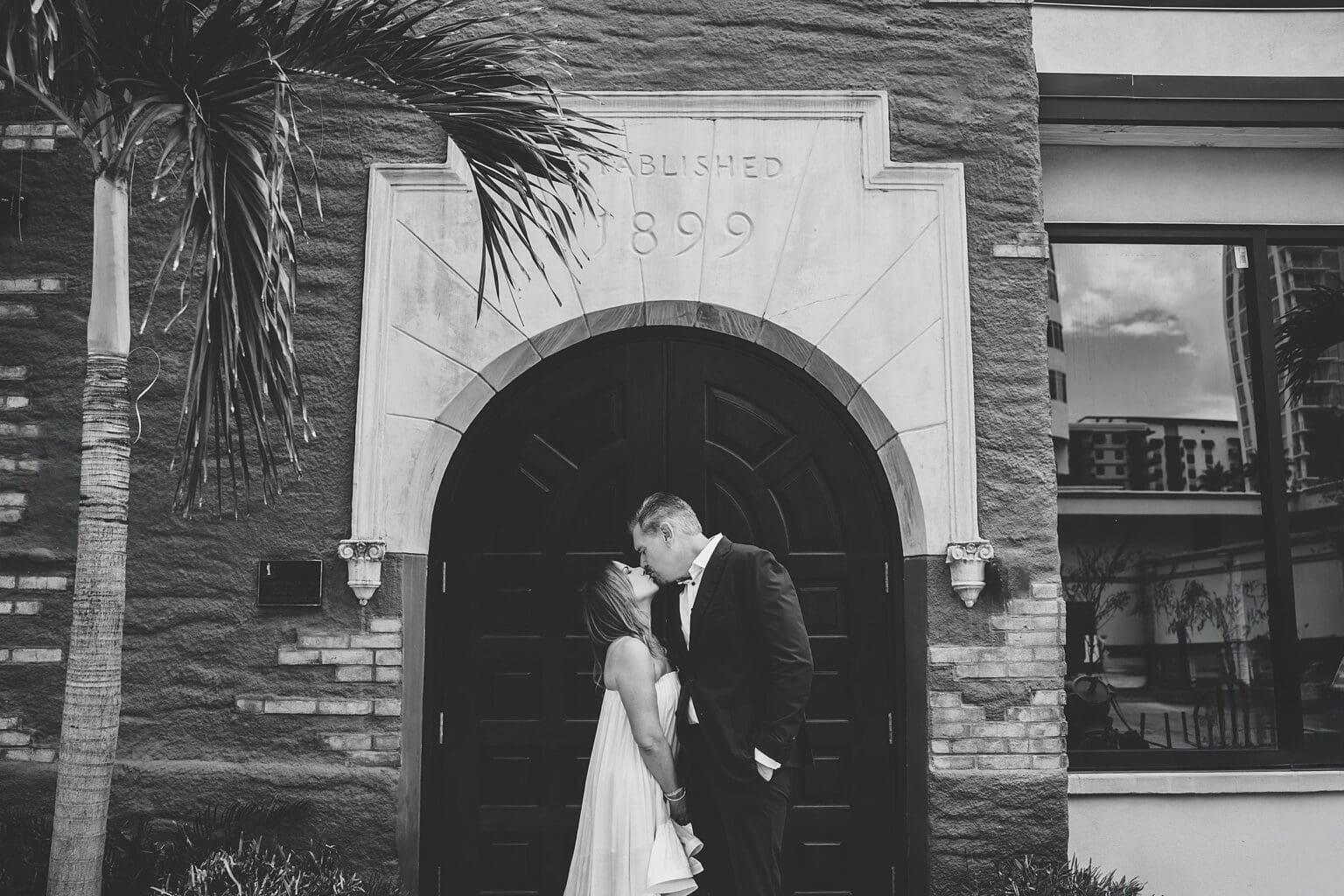 Bride & Groom kissing outside of historical building after Sage Restaurant wedding in downtown Sarasota, FL photographed by Juliana Montane Photography