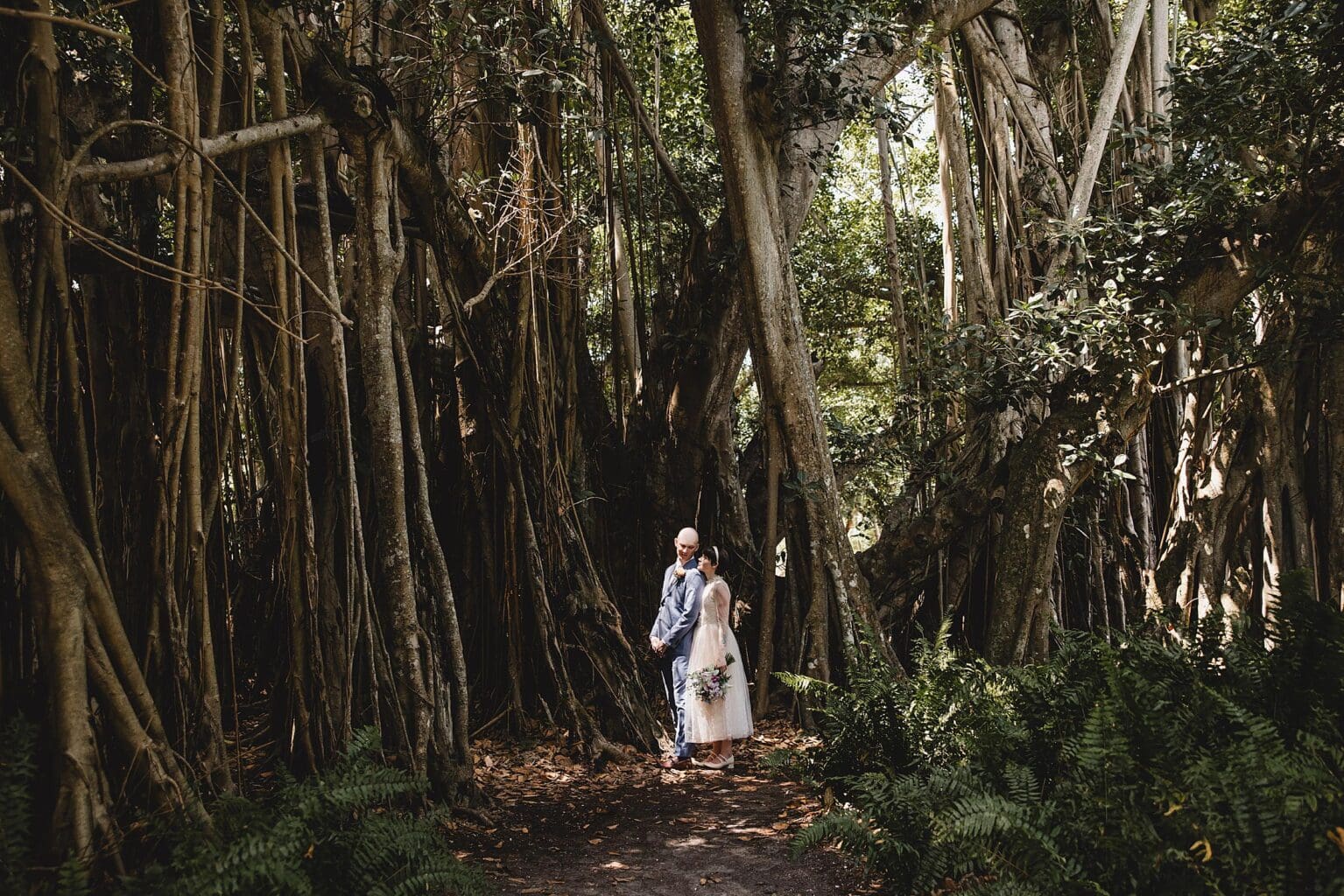 Bride & Groom looking at each other in the banyan trees at Ringling Museum in Sarasota Florida photographed by Juliana Montane Photography