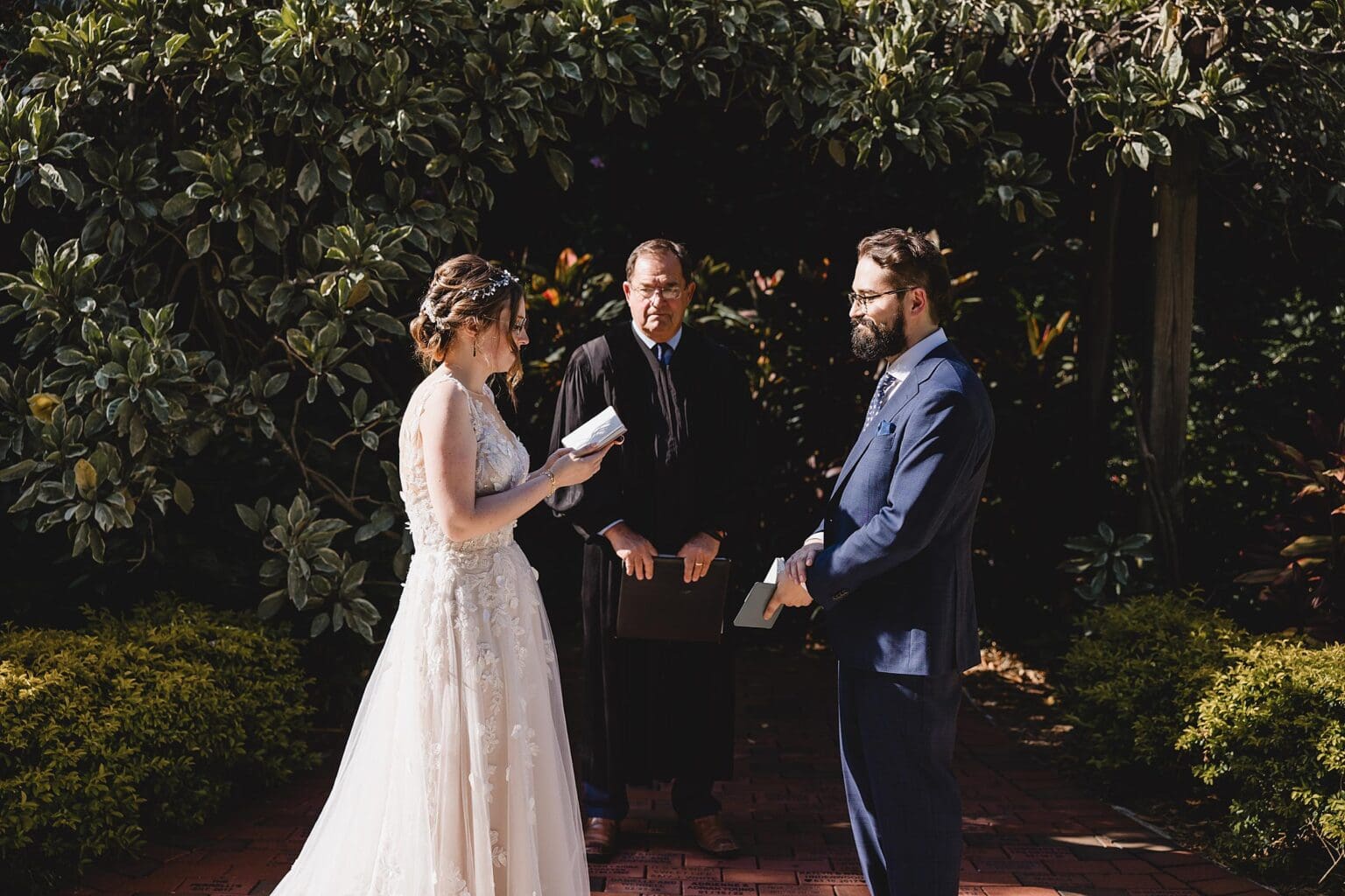 Bride & Groom reading vows at their wedding ceremony at a Sunken Gardens Wedding in St. Petersburg, FL photographed by Juliana Montane Photography