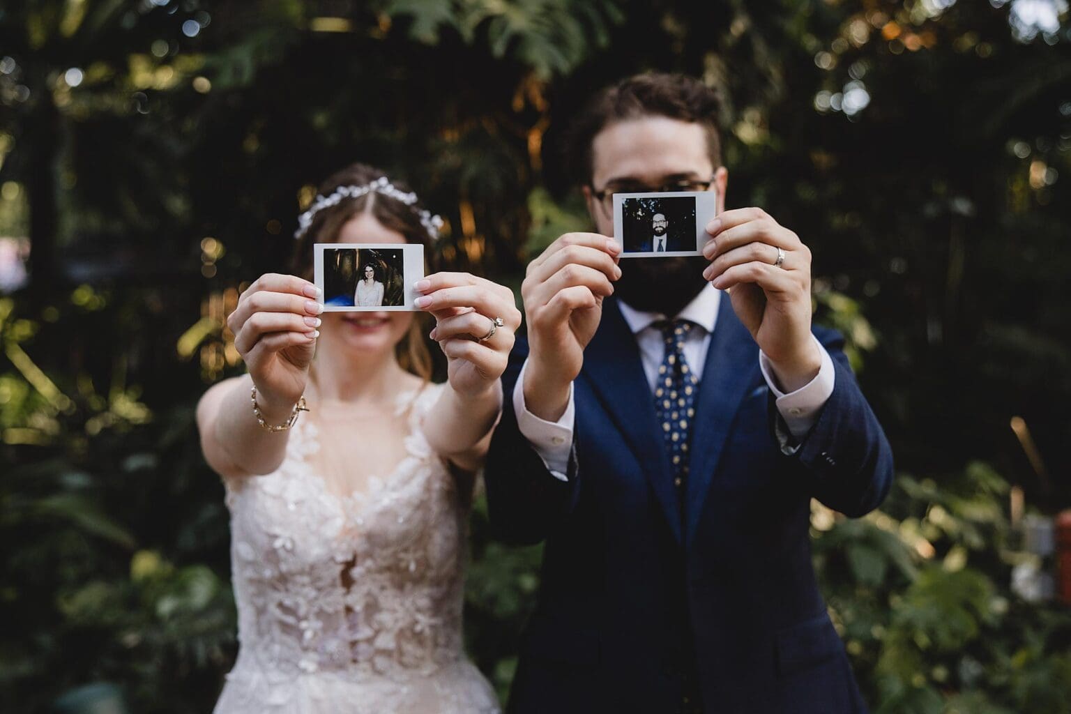 Bride & Groom holding polaroids in front of their faces at a Sunken Gardens Wedding in St. Petersburg, FL photographed by Juliana Montane Photography