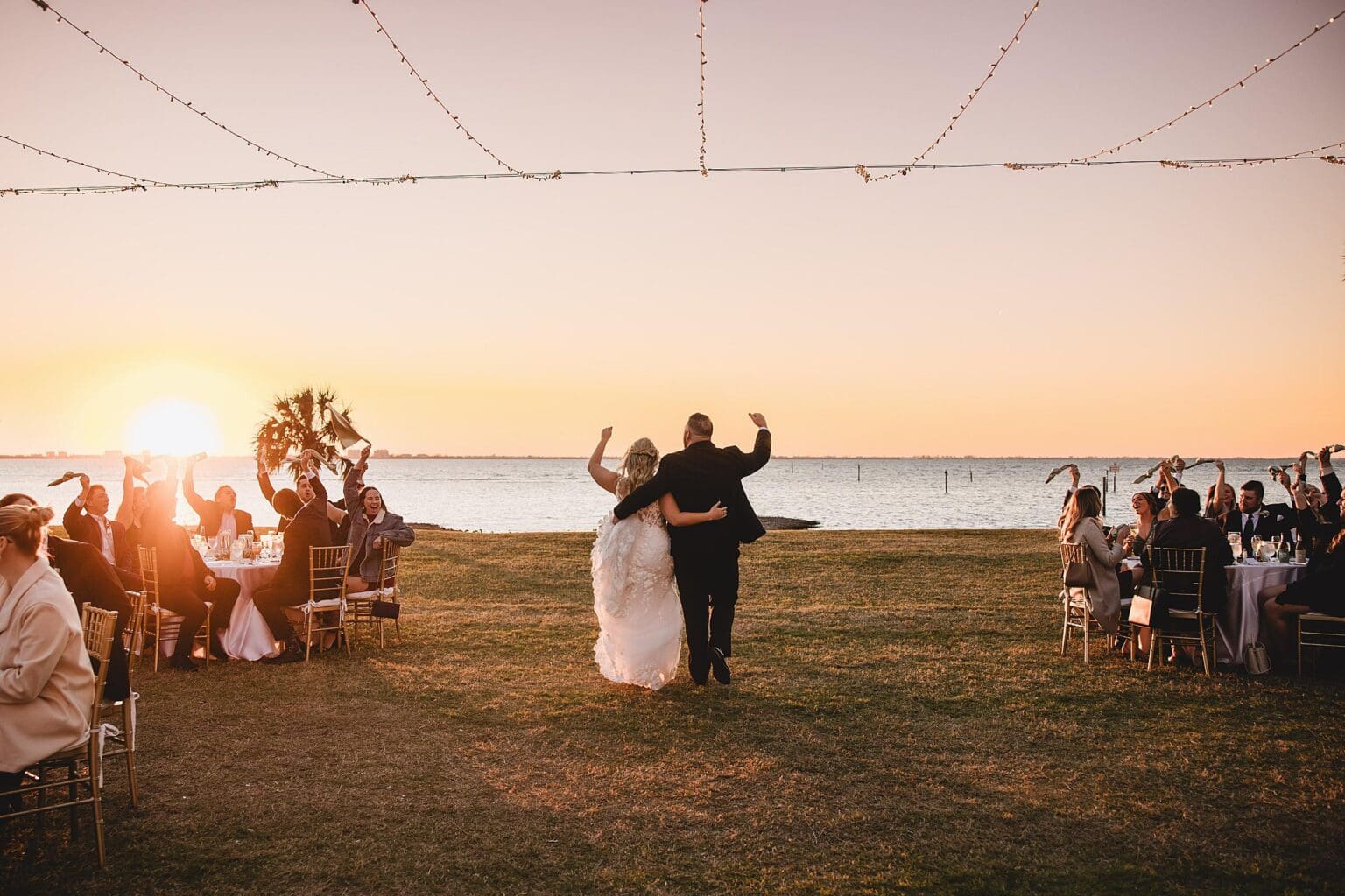 Bride & Groom walking towards the Sarasota Bay away from the Powel Crosley mansion at wedding reception at a Crosley Mansion wedding in Sarasota Florida photographed by Juliana Montane Photography