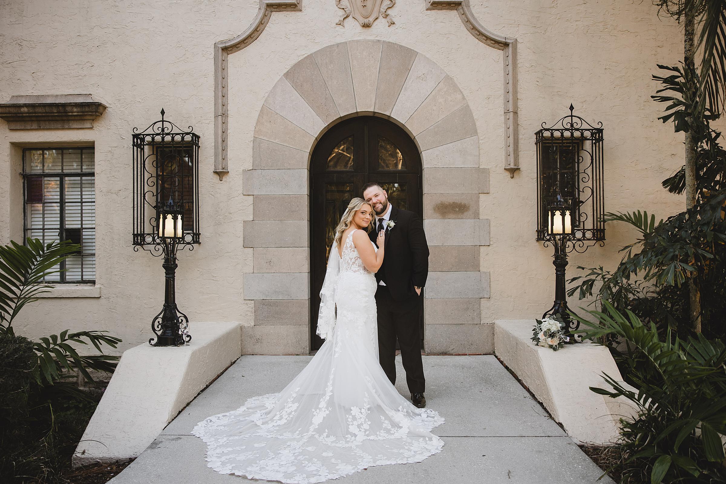 Bride & Groom posing in front of side door at a Crosley Mansion wedding in Sarasota Florida photographed by Juliana Montane Photography