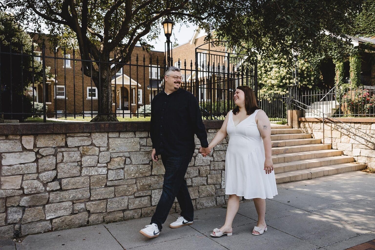 Couple walking in historic Dundee in Omaha, NE during engagement session photographed by Juliana Montane Photography