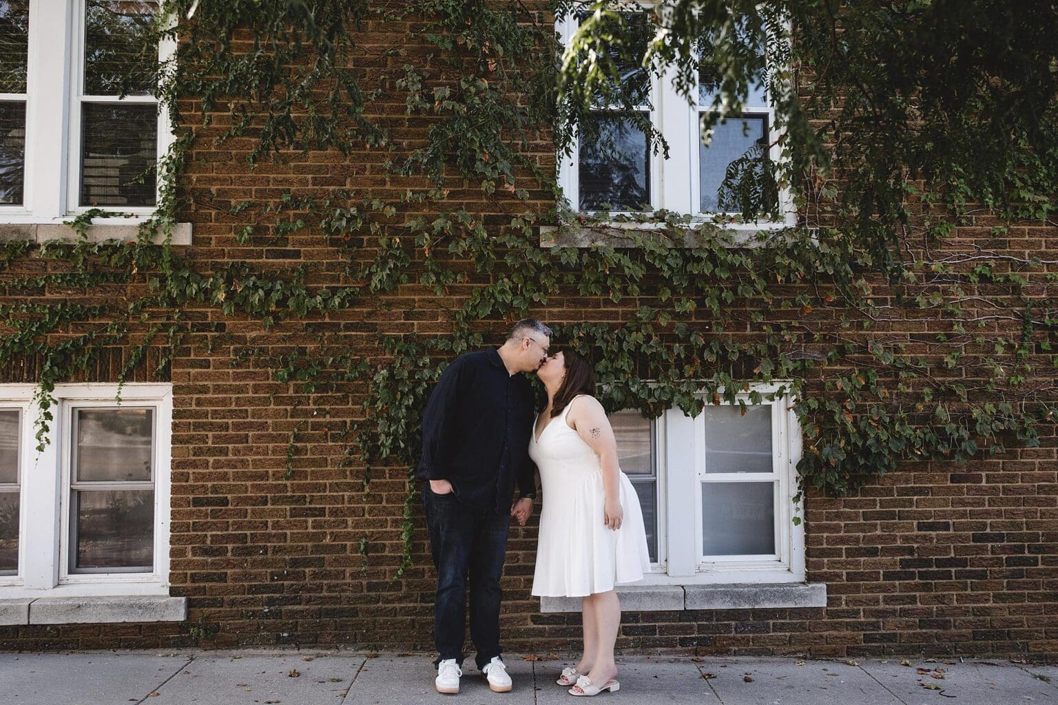 Couple kissing in historic Dundee in Omaha, NE during engagement session photographed by Juliana Montane Photography