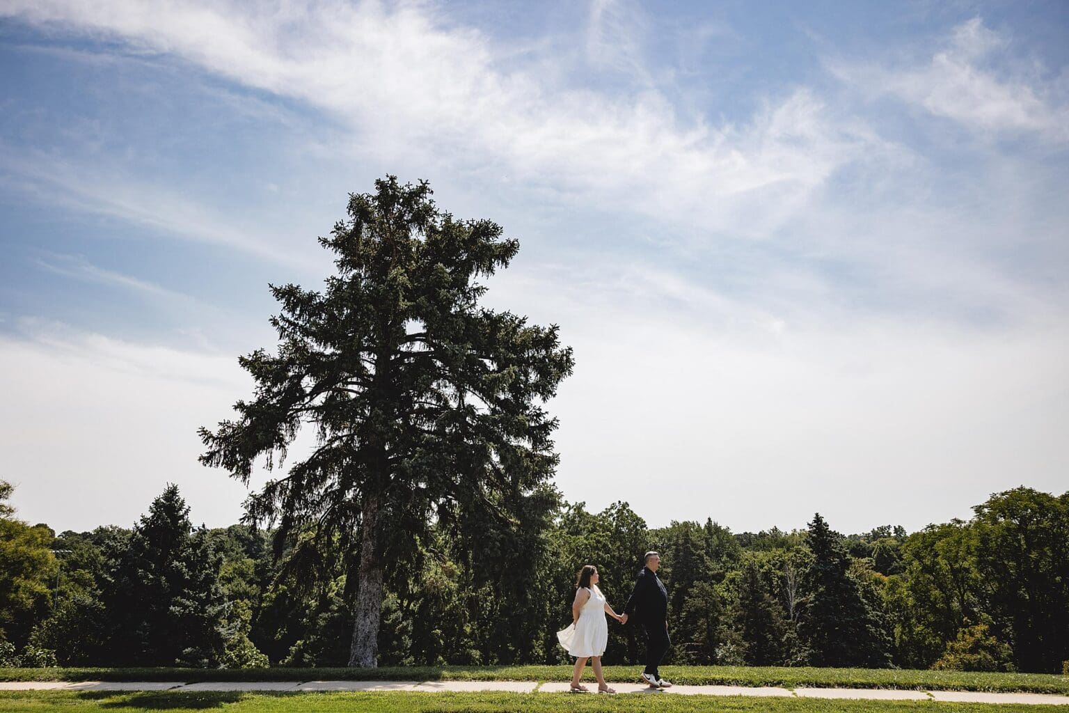 Engagement photos of couple walking in Memorial Park in Omaha, NE during engagement session photographed by Juliana Montane Photography