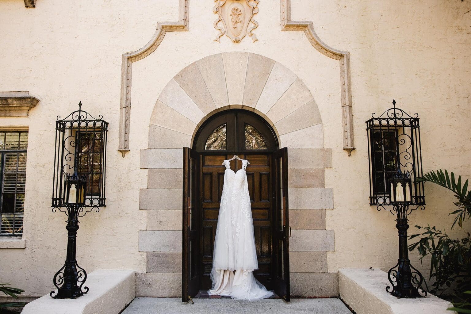 Wedding dress hung on historic door at Powel Crosley Mansion wedding in Sarasota, FL photographed by Juliana Montane Photography