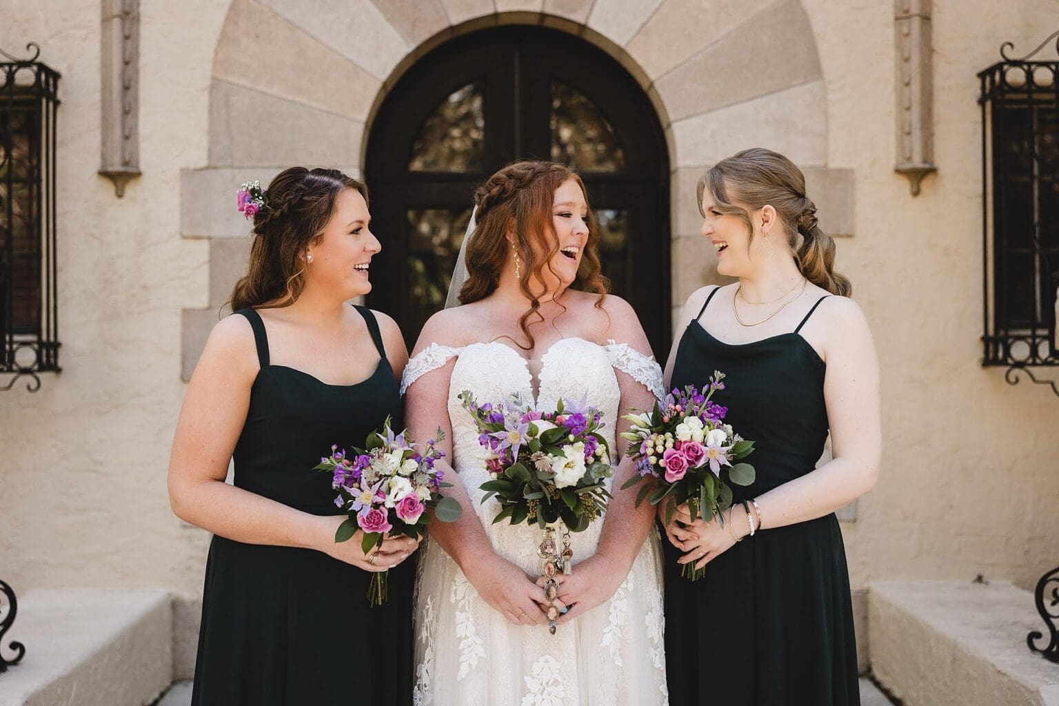 Bride with sisters holding wedding floral bouquets at Powel Crosley Mansion wedding in Sarasota, FL photographed by Juliana Montane Photography