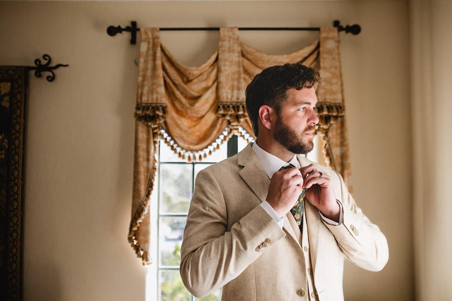 Groom adjusting his tie at Powel Crosley Mansion wedding in Sarasota, FL photographed by Juliana Montane Photography