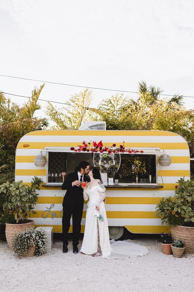 Bride & Groom kissing in front of pop up bar at The Fox Mercantile in Bradenton Florida photographed by Juliana Montane Photography
